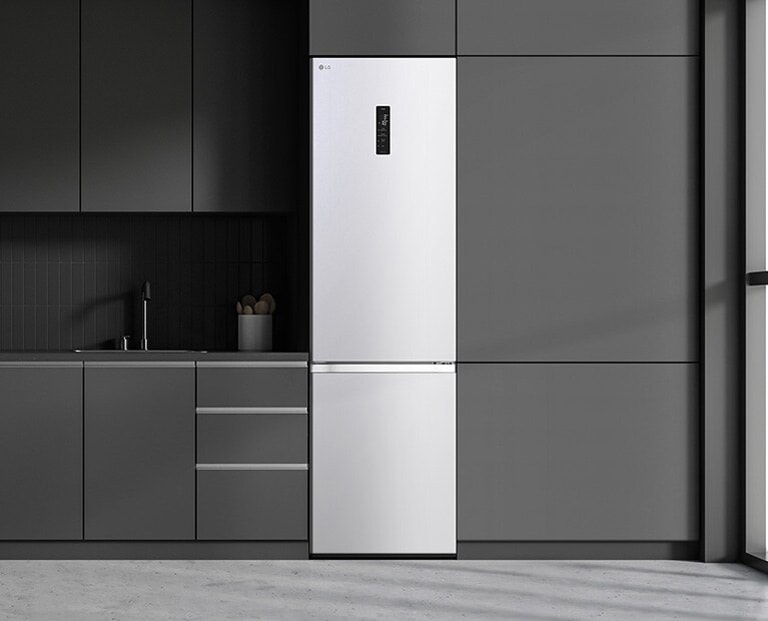 Сучасна кухня з холодильником, який ідеально вписується в кухонні шафи, нагадуючи вбудовану модель.