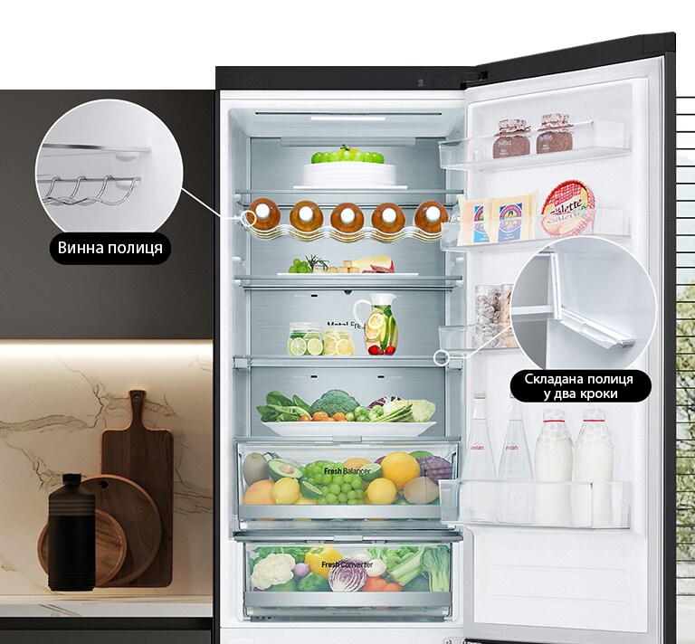 В холодильнику, який наповнений свіжими продуктами, відкриті дверцята, та демонструється наявність винної та складаної полиць.