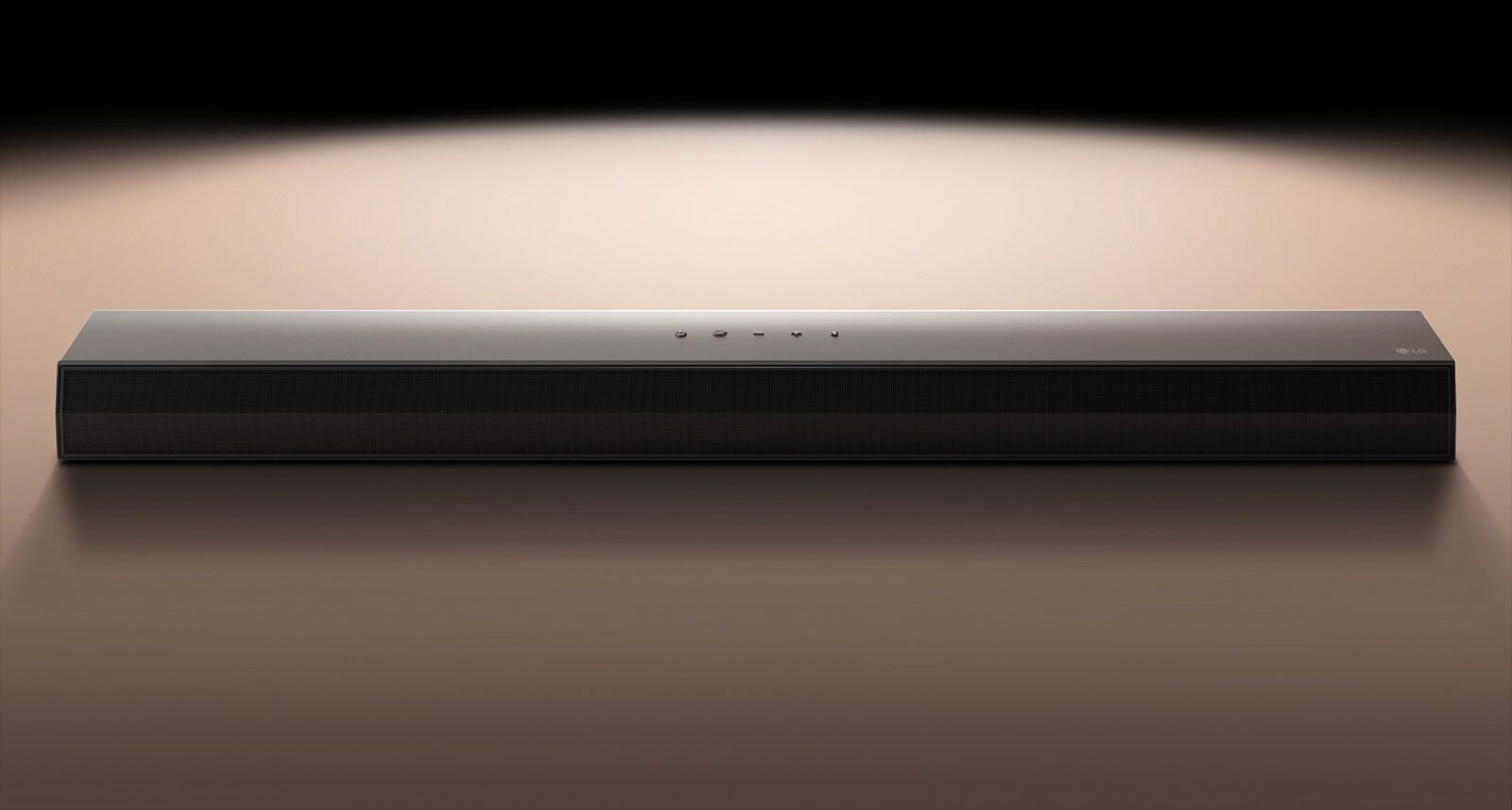LG Soundbar на чорному тлі, підсвіченому прожектором.