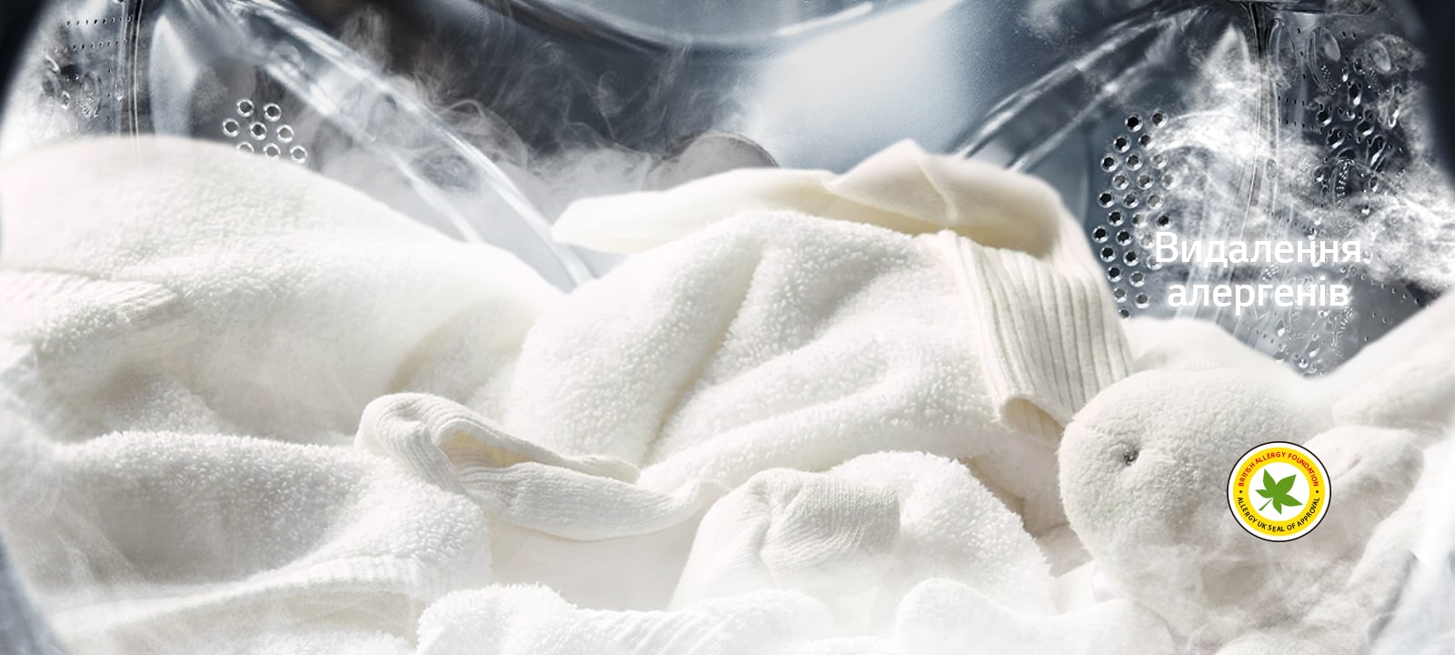 М’який білий халат і м'яка іграшка зображені з парою в барабані пральної машини.