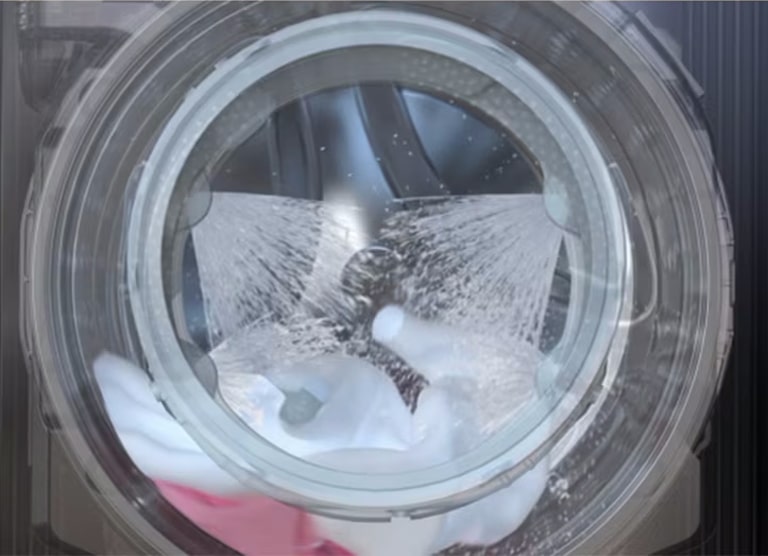 Зображення барабана пральної машини під час роботи з технологією TurboWash™ 360°, що розпилює воду з 4 форсунків довкола дверей для швидкого та ефективного очищення одягу.