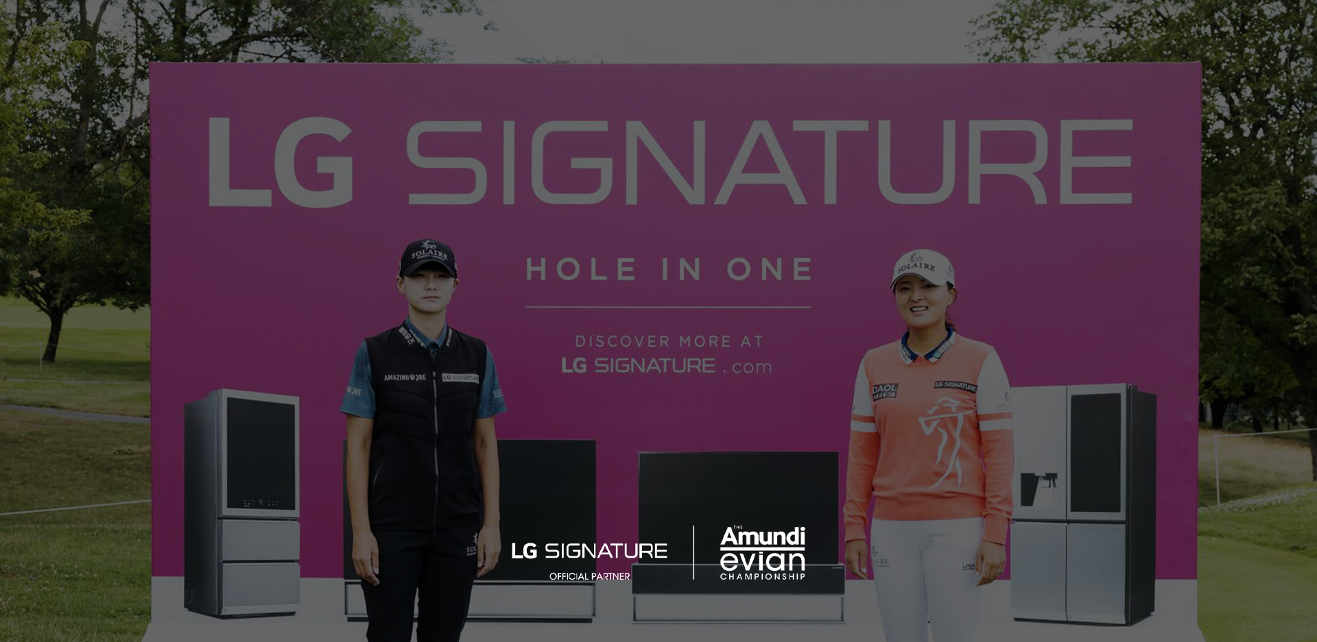 A pink LG SIGNATURE ad on a golf course, featuring product images with two people standing in the foreground against a verdant landscape.
