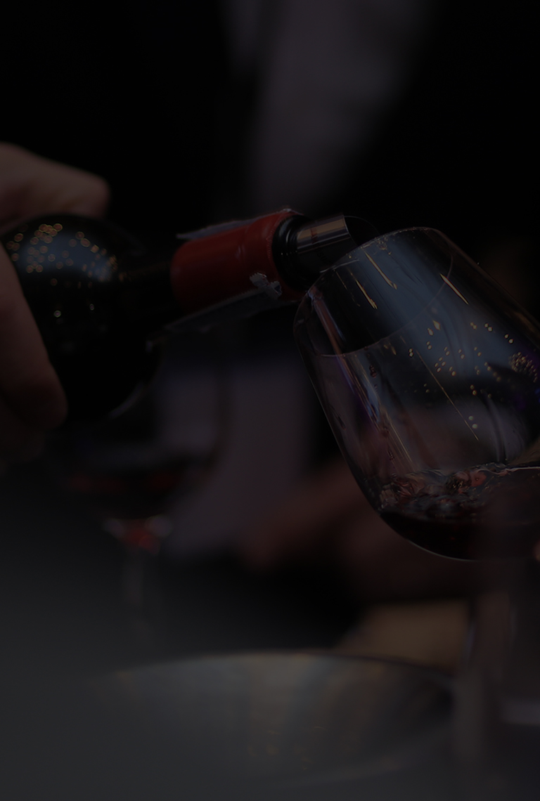 James Suckling is pouring wine into the wine glass.