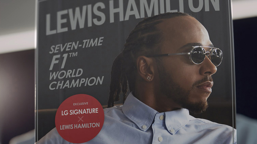 Lewis Hamilton reading a magazine that has a picture of himself on the front page.