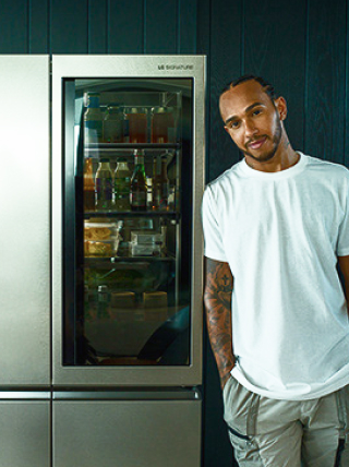 Lewis Hamilton stood next to an LG SIGNATURE Refrigerator.