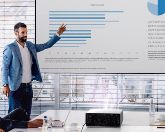 Man pointing to chart data on a projector screen