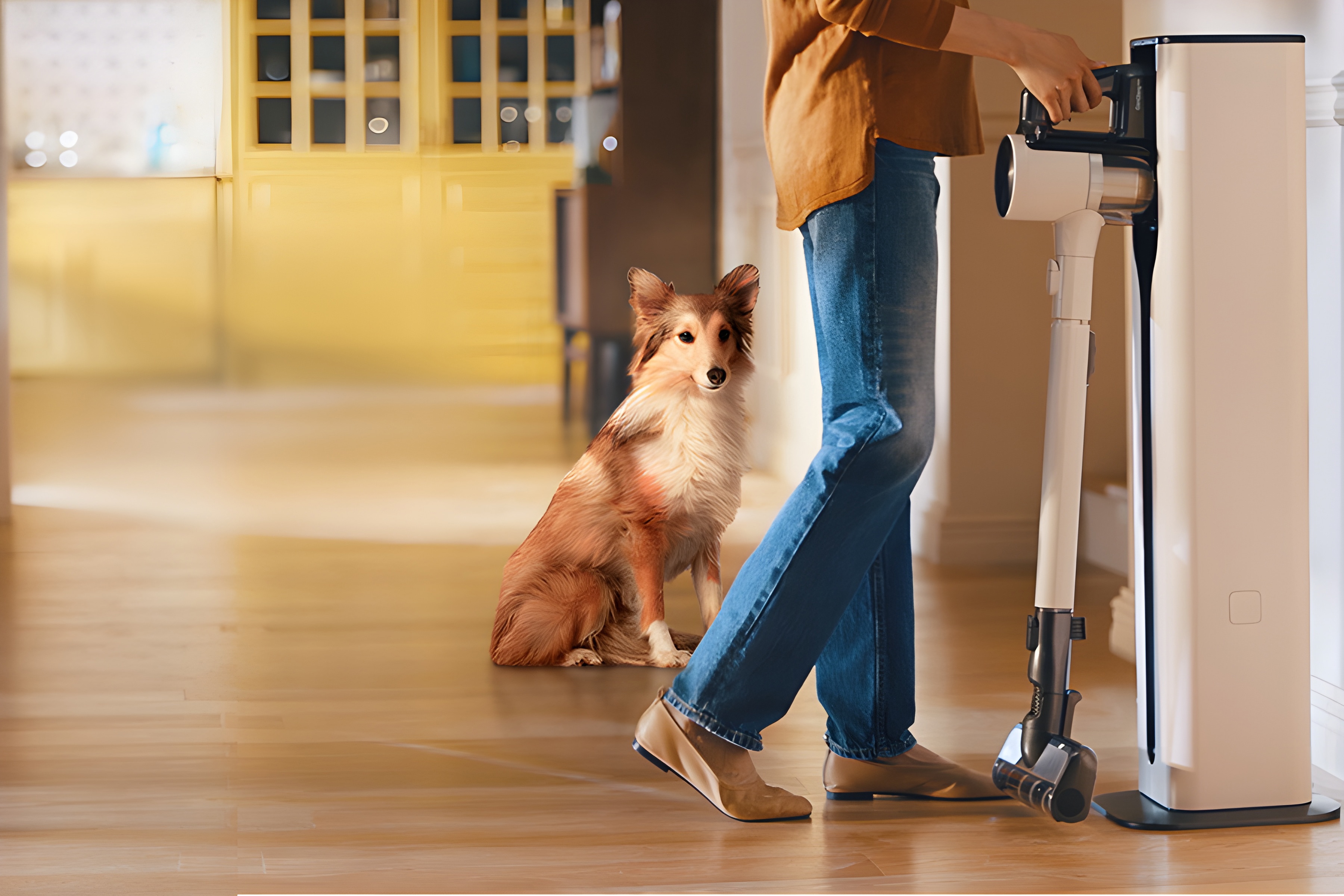 Woman placing LG Cordless Vacuum in standalone docking station next to dog