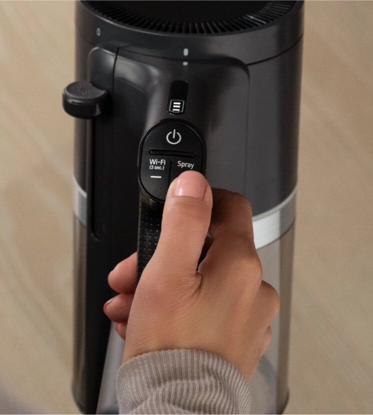 Person pressing Spray Button on LG All-in-One Vacuum