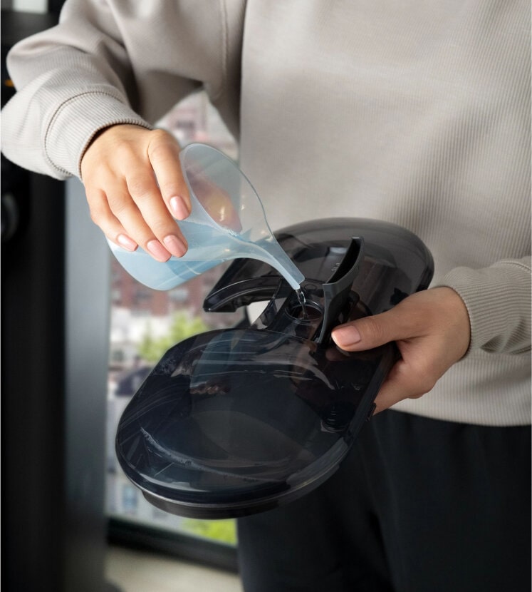 Person filling LG All-in-One Vacuum with detergent