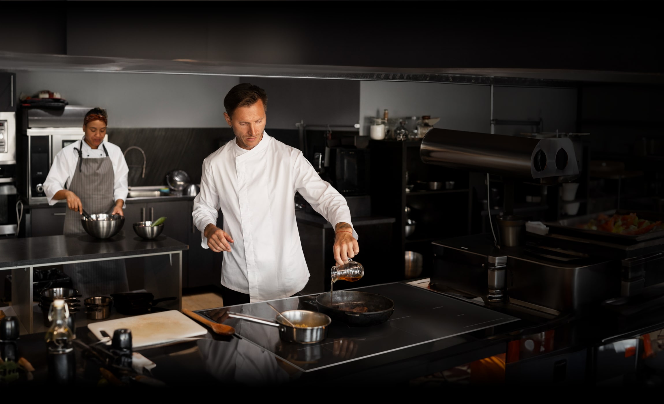 Chef cooking on an induction cooktop.