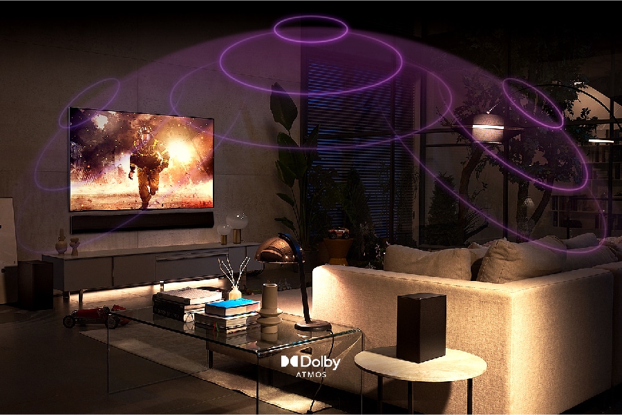 An action movie plays on-screen while sound waves reverberate around the living room. Dolby Atmos logo.