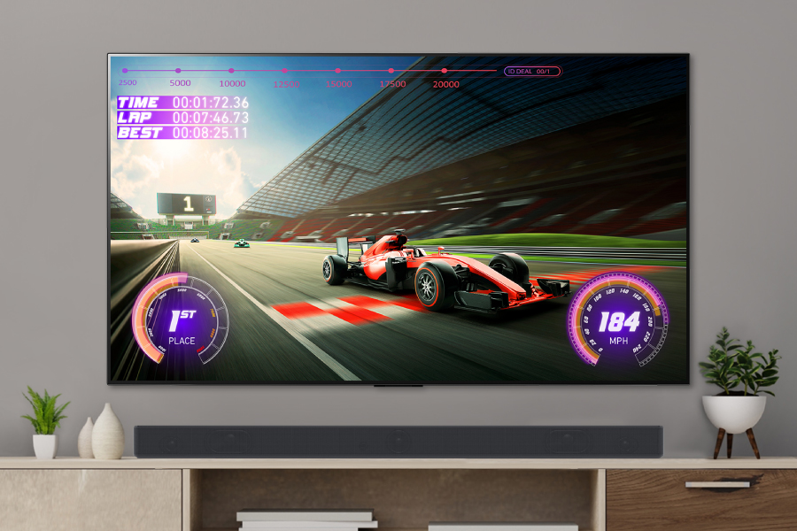 A racing game plays on-screen with a sound bar placed under the TV.
