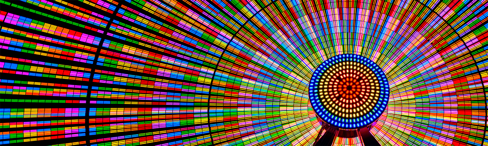 The Ferris wheel shines brightly with vibrant colors.