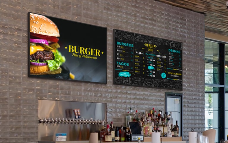 Two UV5N-E units powered by BrightSignOS are installed on the wall of a restaurant.