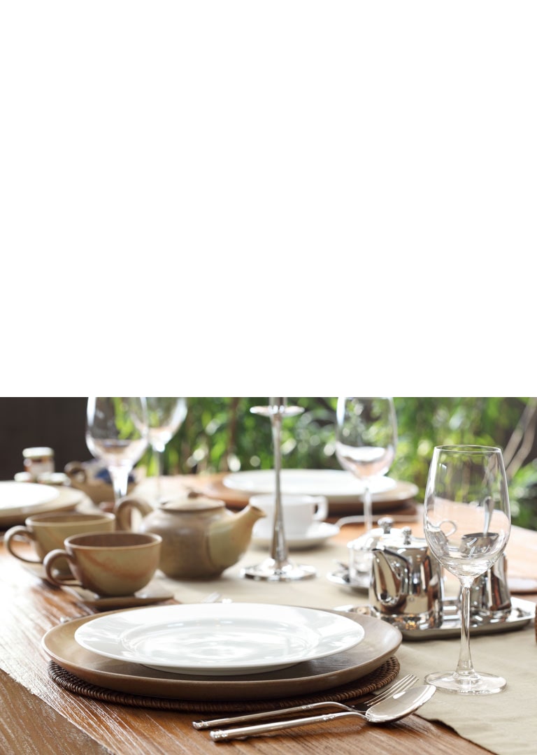 A sparkling table with sanitized dishes and glasses.