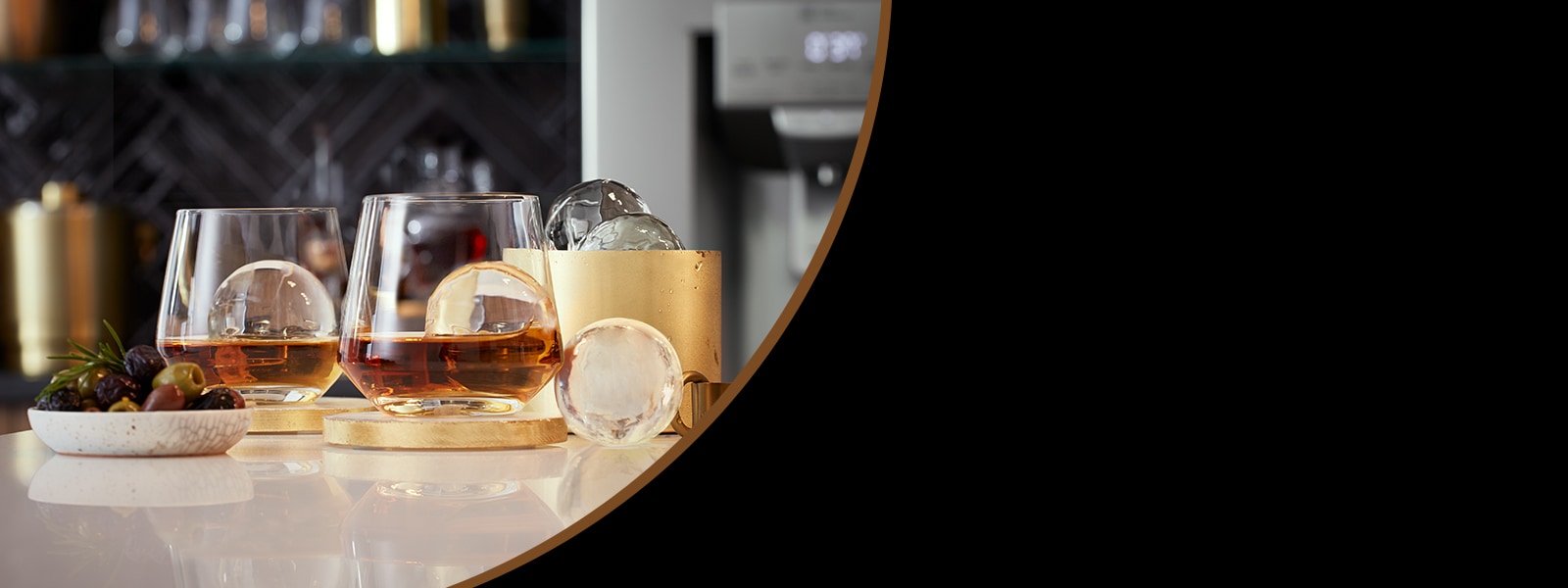 Alcoholic tumbler glasses on a table surrounded by ice and fruit.