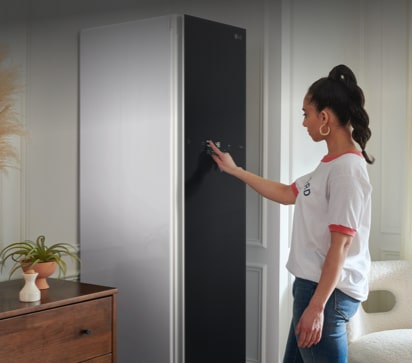 Woman using streamlined intuitive LED control panel on LG Styler steam closet