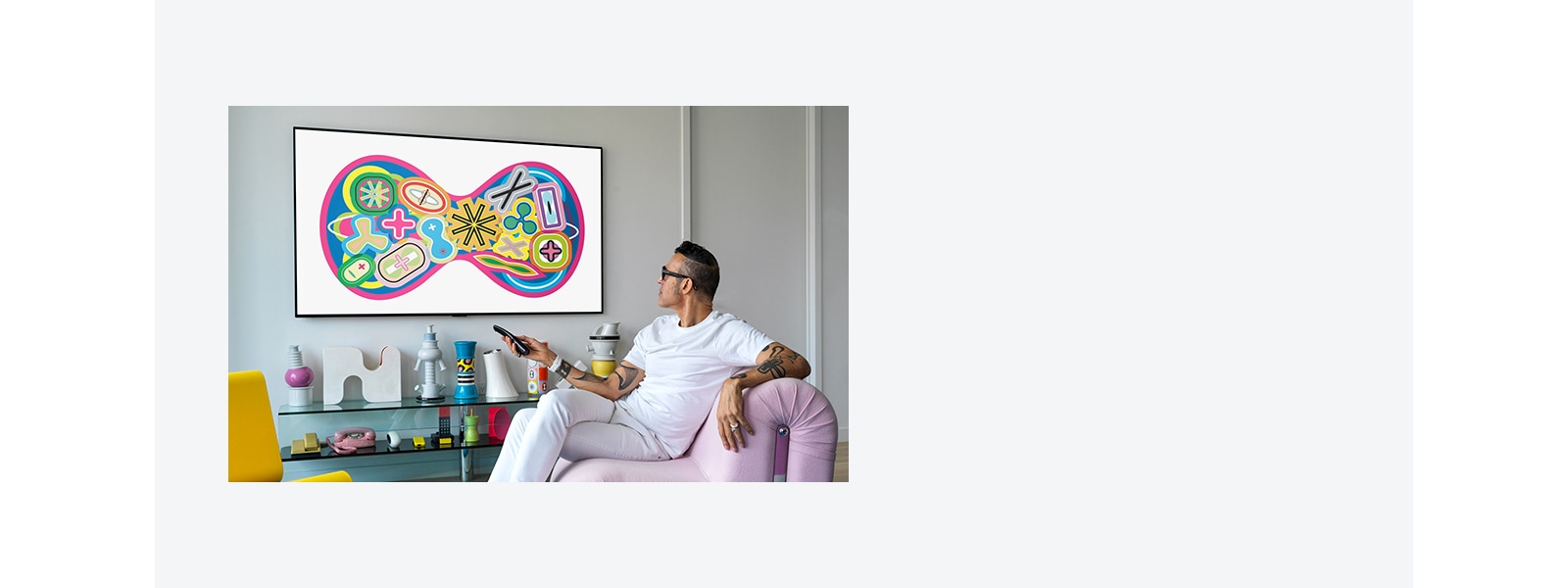 A man sitting on a chair enjoying a gallery on TV