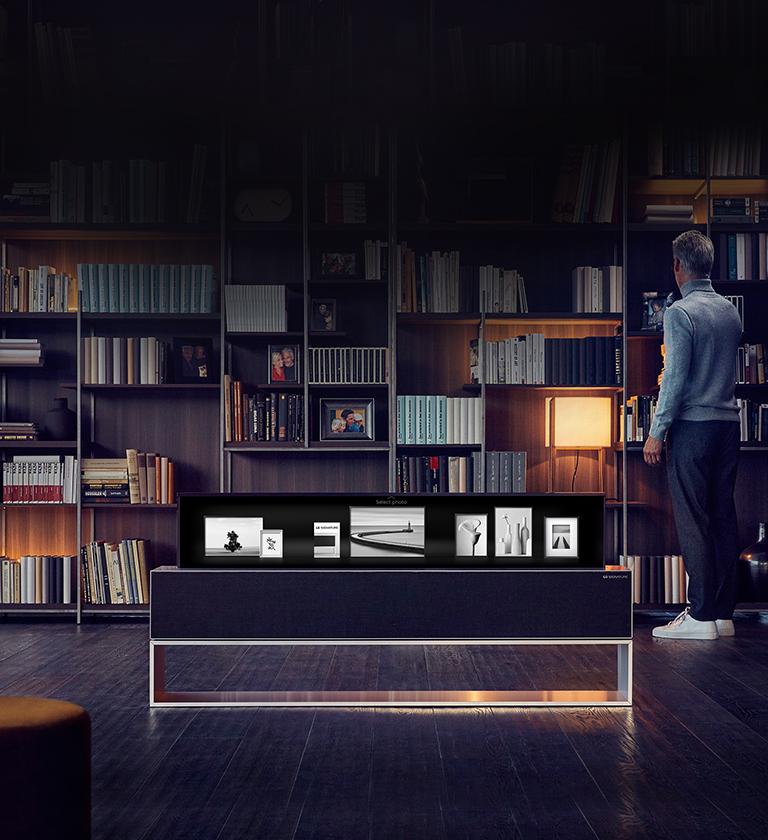 Woman standing near a window watching a beach view from her bedroom.