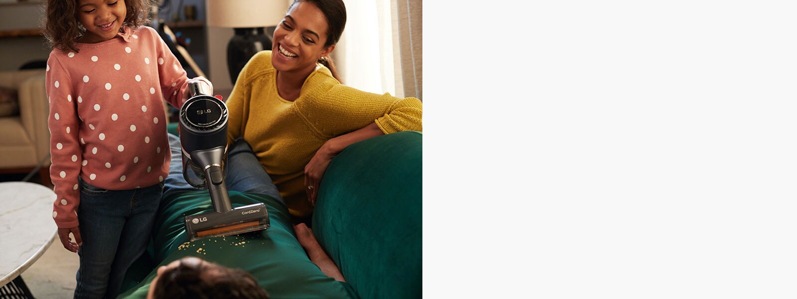 Mother and daughter vacuuming the couch using an LG Vacuum