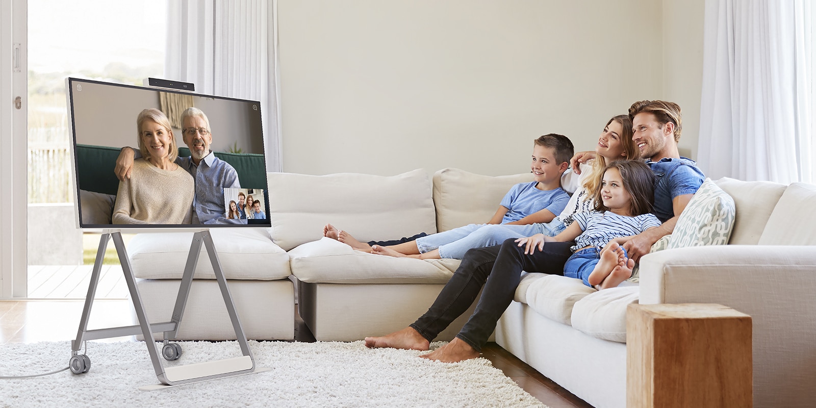 " A family is making a video call using the product in the living room"