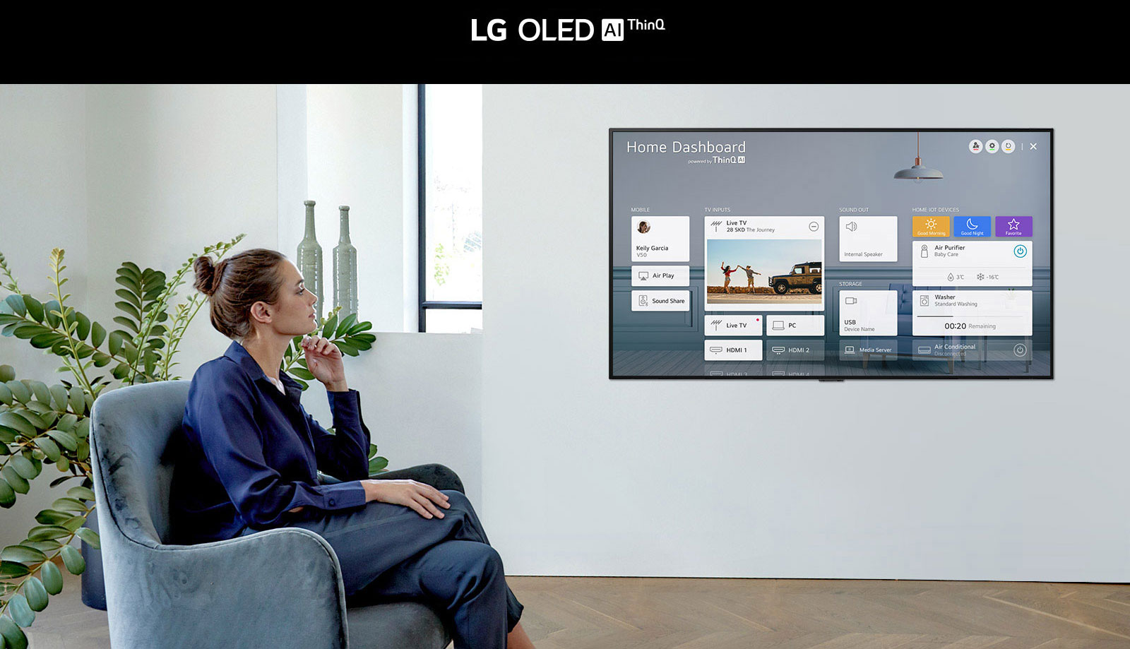 Woman sitting on a chair in the living room with the Home Dashboard on the TV screen