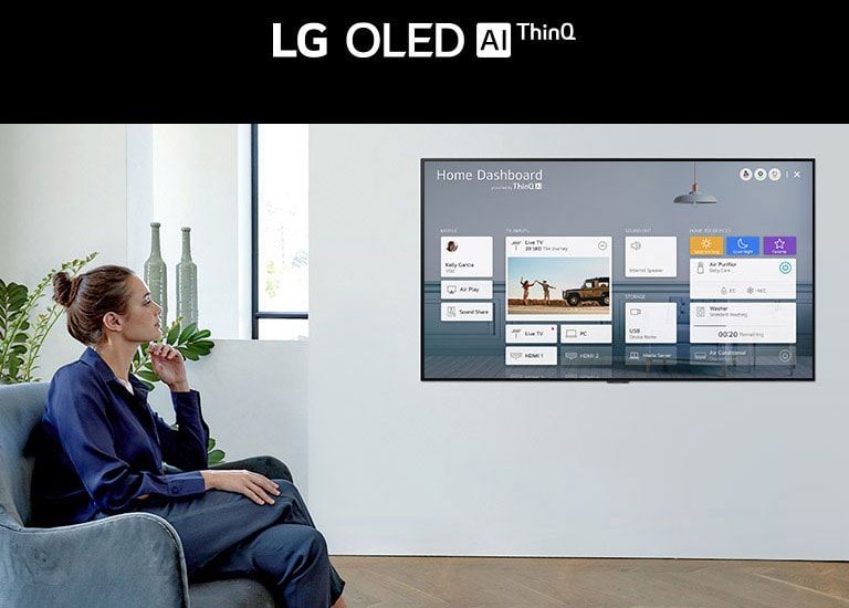 Woman sitting on a chair in the living room with the Home Dashboard on the TV screen