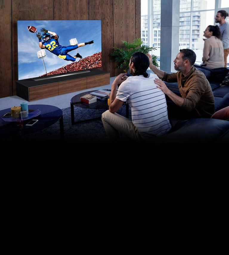 People watching a Tottenham game on TV in the living room