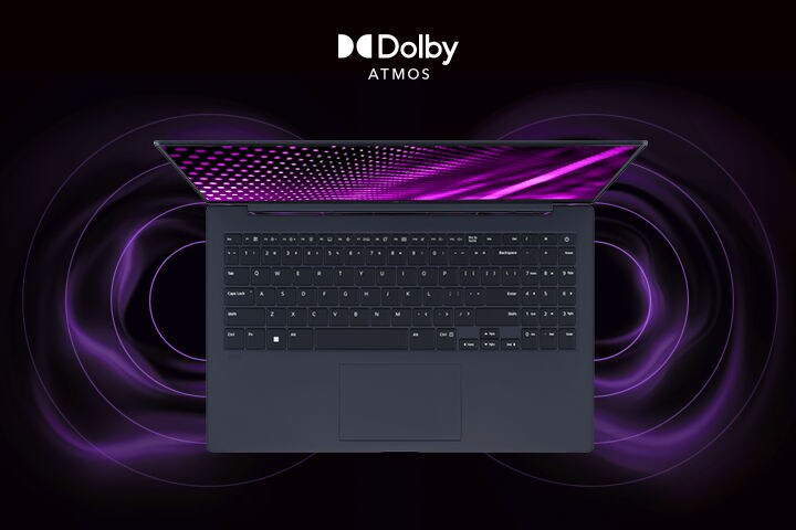 The image shows a top-down view of a gray laptop with a vibrant, purple-themed graphic on the screen. Surrounding the laptop are dynamic sound wave visuals, indicating an immersive audio experience. The "Dolby Atmos" logo is displayed in the bottom right corner.