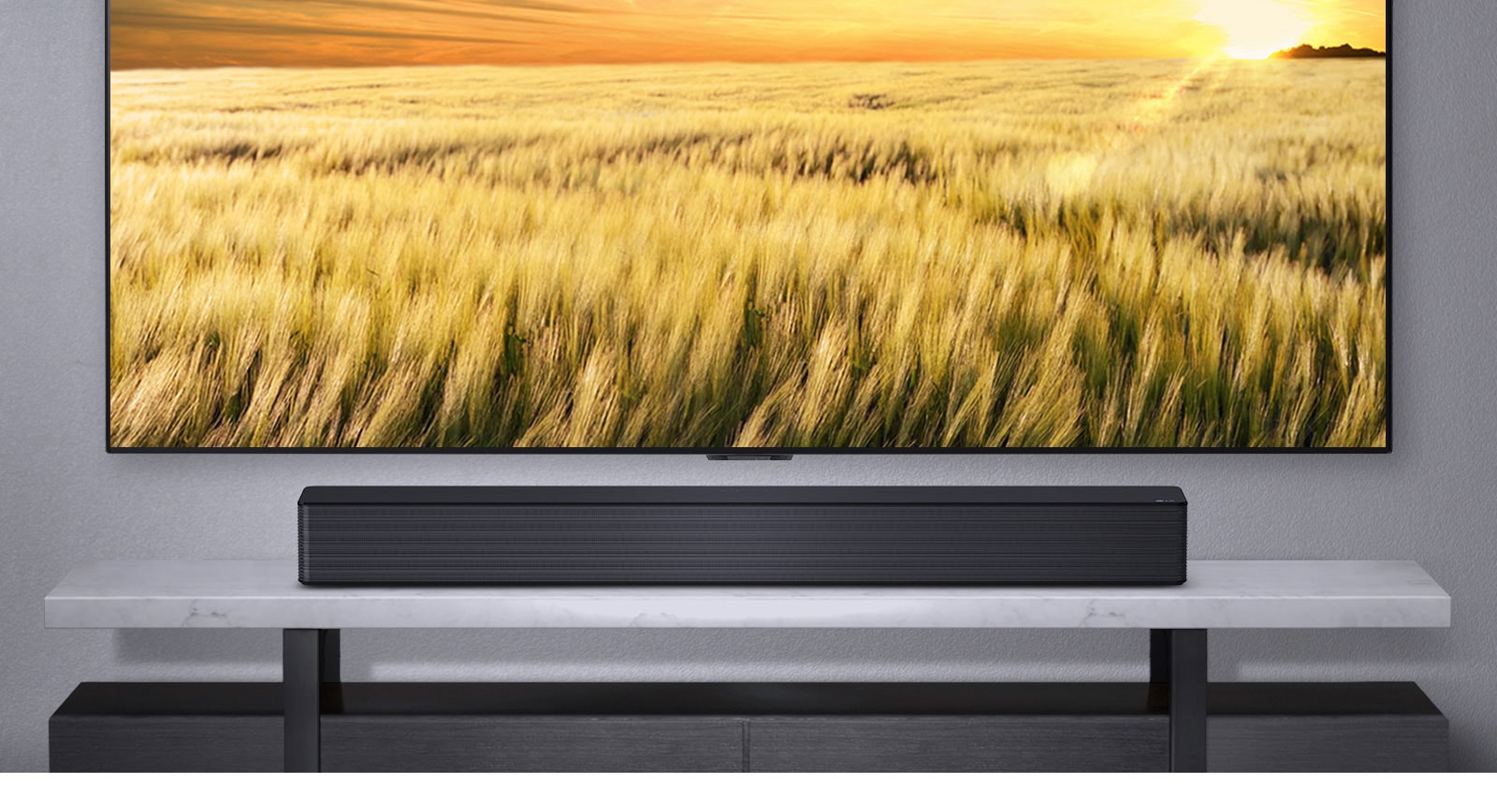 A TV is shown on a gray wall and LG Soundbar below it on a gray shelf. Blue-Ray disk below the shelf.