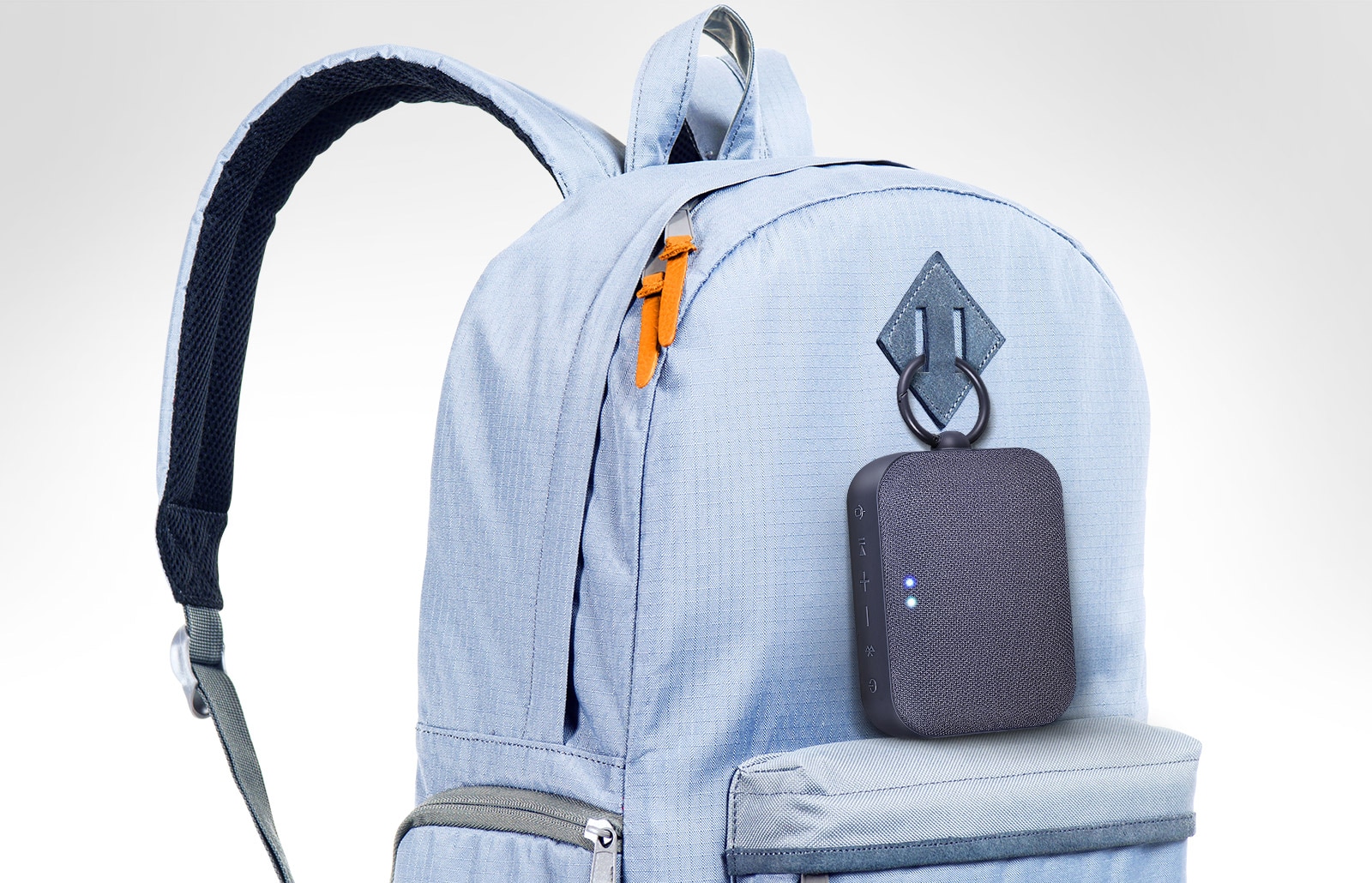 LG XBOOM Go PN1 is clipped onto the sky blue colored backpack.