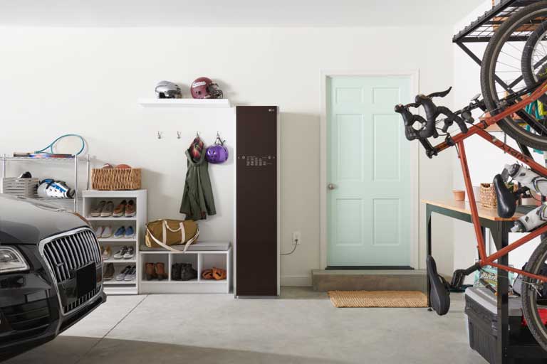 Image of slim LG Styler placed in garage next to car and bicycle