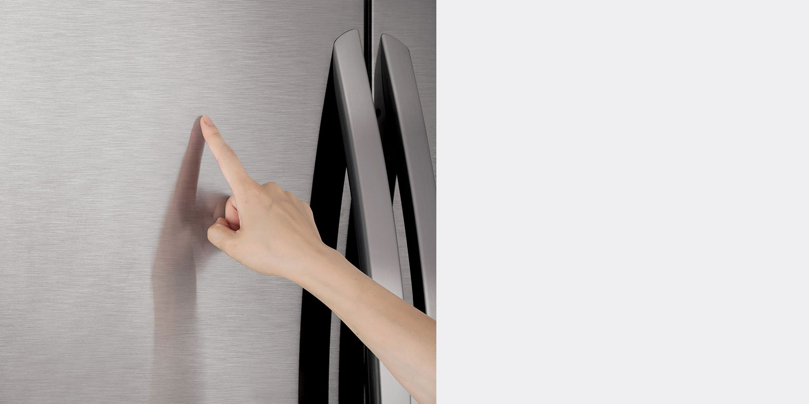 a person touching stainless steel exterior of refrigerator