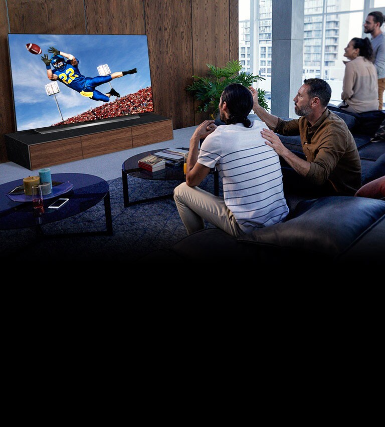 People watching a Tottenham game on TV in the living room