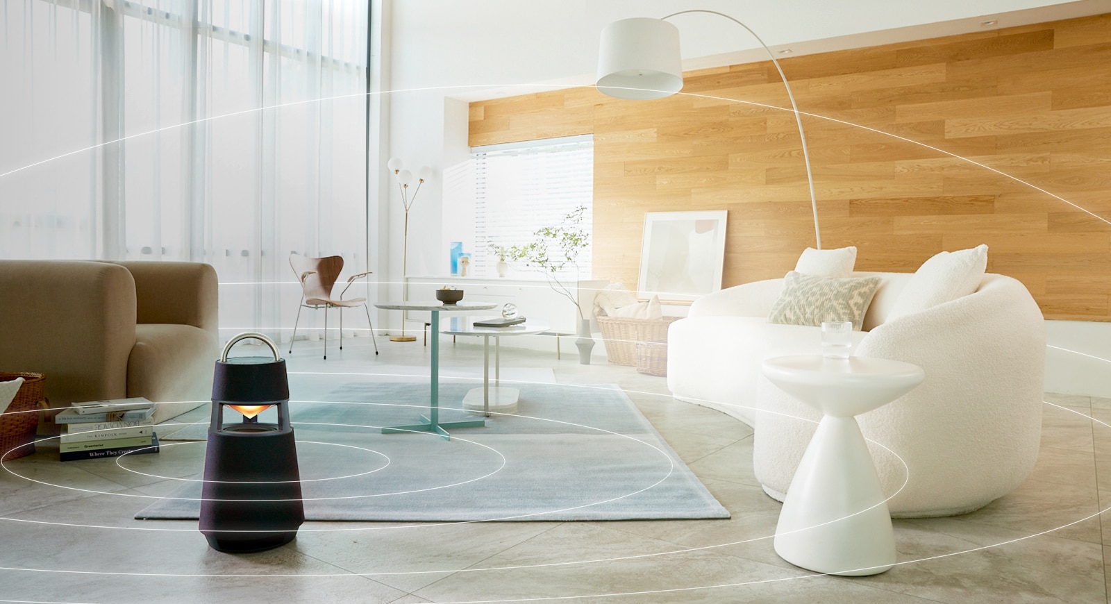 Image of sound waves spreading around XBOOM 360 lying on the floor of a minimal living room space.