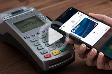 Hand holding an LG phone over payment machine.