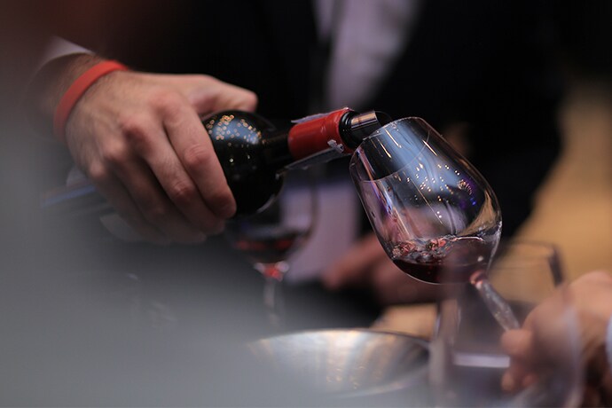 James Suckling is pouring wine into the wine glass.