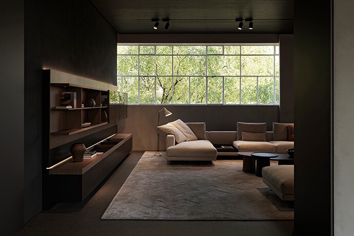Couches and side tables are arranged in the living room with a long window across the whole wall.