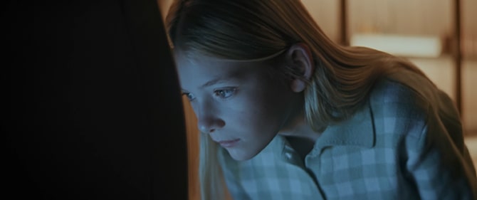 Close-up image of a young girl bending down to look at an LG SIGNATURE product.