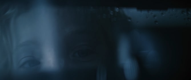 Close-up image of a girls face reflected in the water and glass of an LG SIGNATURE Air Purifier.