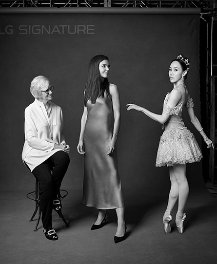 The women are standing in fornt of LG SIGNATURE photo zone