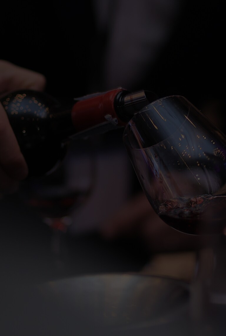 James Suckling is pouring wine into the wine glass.