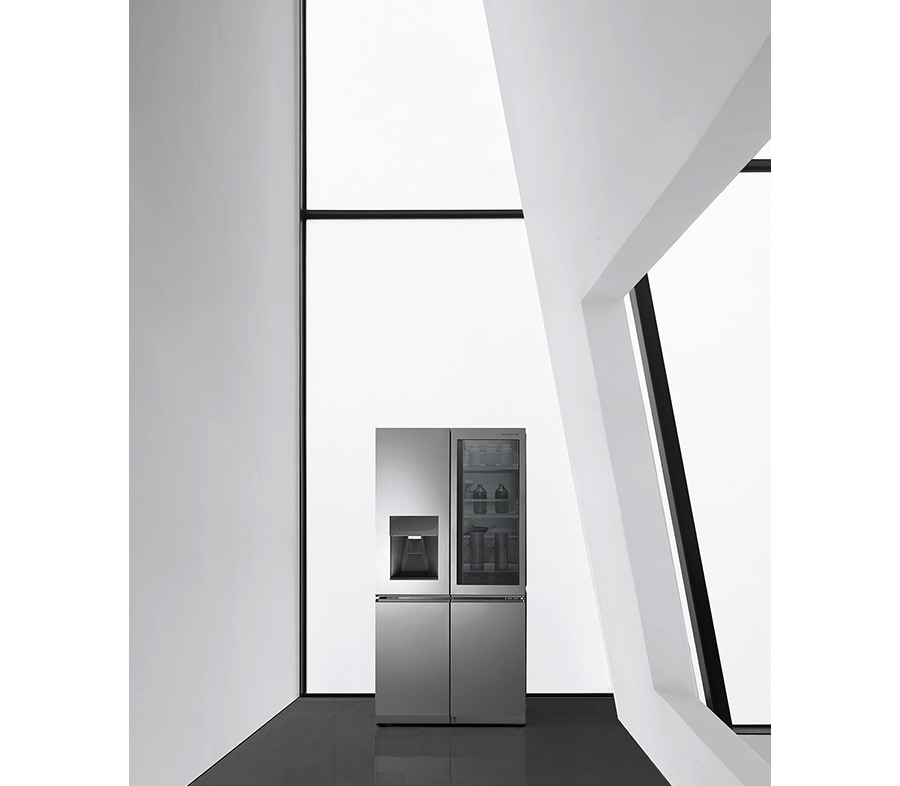 a black and white image of lg signature oled tv which is hung on the wall and to the left there is a spiral staircase