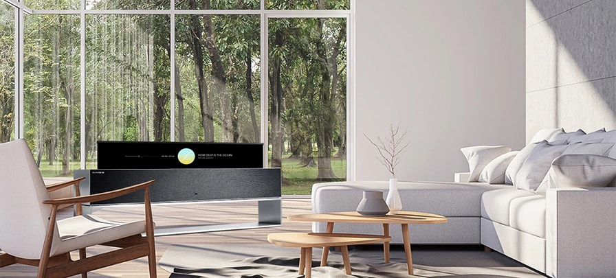 LG SIGNATURE R in a white-themed room in front of a large window with a view of a forest