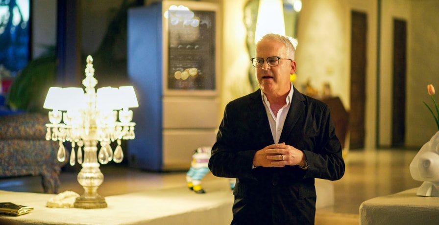 Standing up, James Suckling addresses an audience as he talks about his personal experience with SIGNATURE wine cellars, as a wine expert.