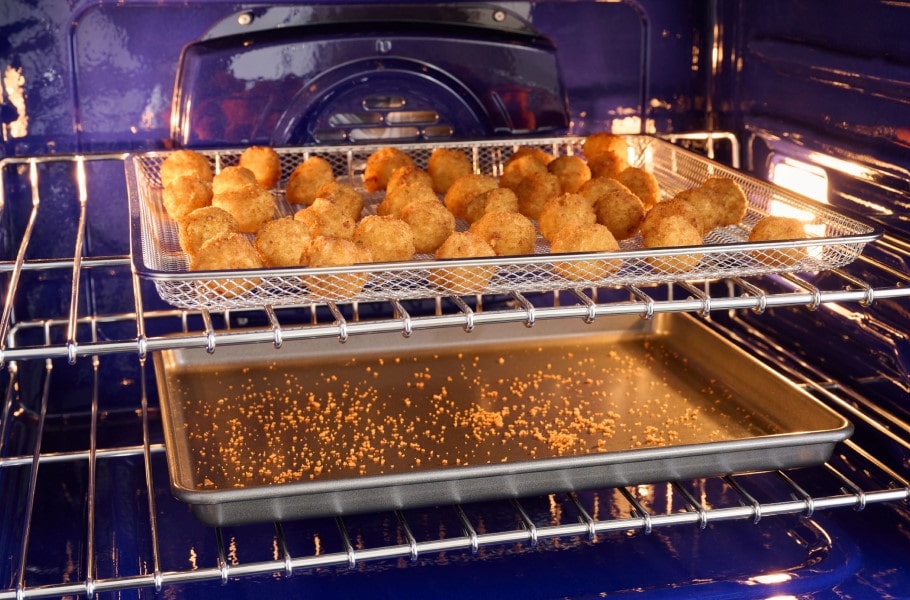 Crispy food being air fried in an LG Studio oven using the Air Fry function, with convection heat circulating.