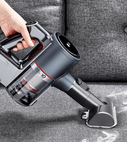 Person Using the Power Punch Nozzle Attachment (AGB74252404) on the LG CordZero as a Pet Hair Vacuum to Remove Dog Hair from Furniture.