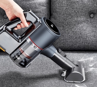 Person Using the Power Punch Nozzle Attachment (AGB74252404) on the LG CordZero as a Pet Hair Vacuum to Remove Dog Hair from Furniture.