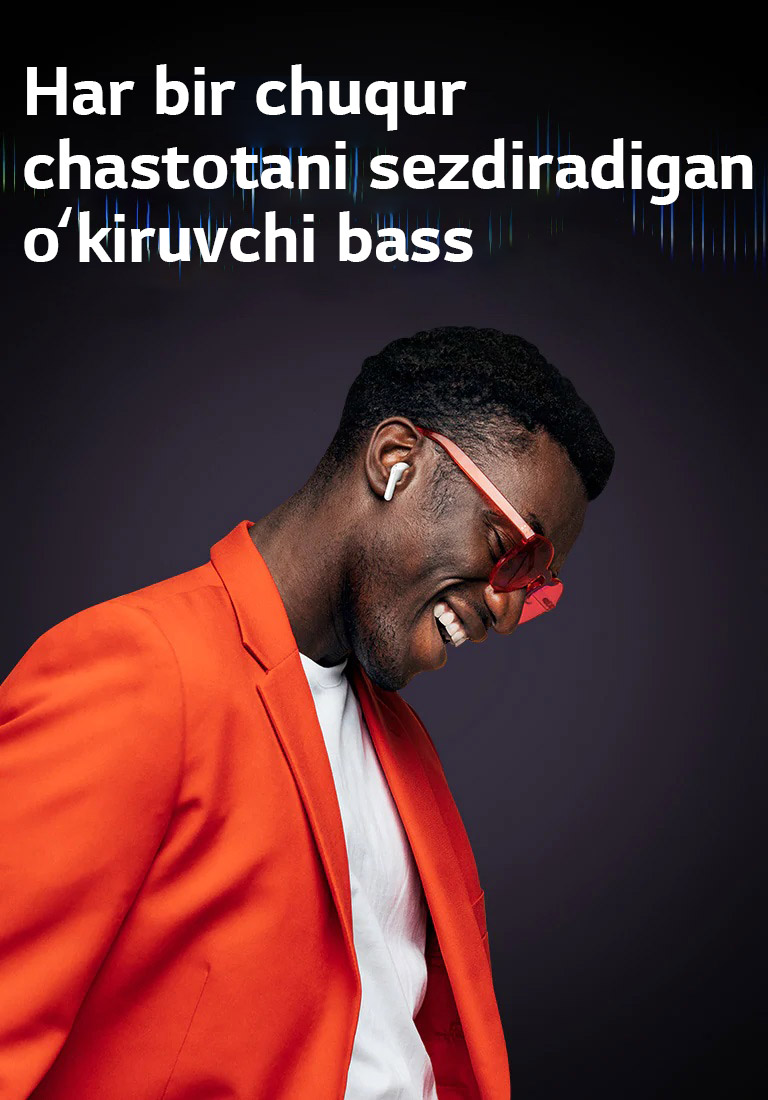 Toʻq sariq kostyumdagi erkak TONE Free quloqliklarida musiqa tinglamoqda.