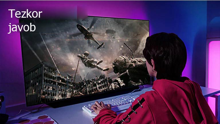 Qizaloq katta ekranli televizorda kompyuter oʻyinini oʻynamoqda va monitorda vertolyotdan sakrayotgan askar aks etgan.